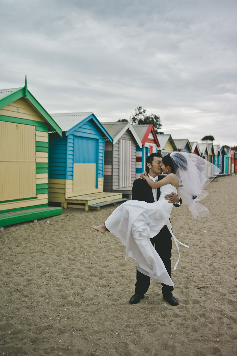Groom carrying bride at Brighton beach