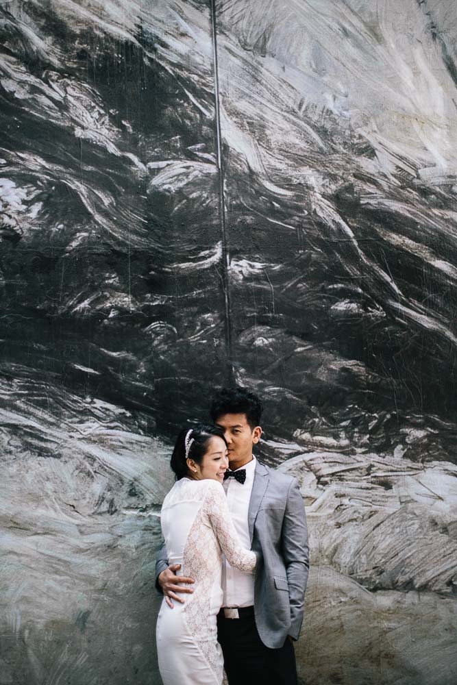 Wedding couple in front of graffiti wall