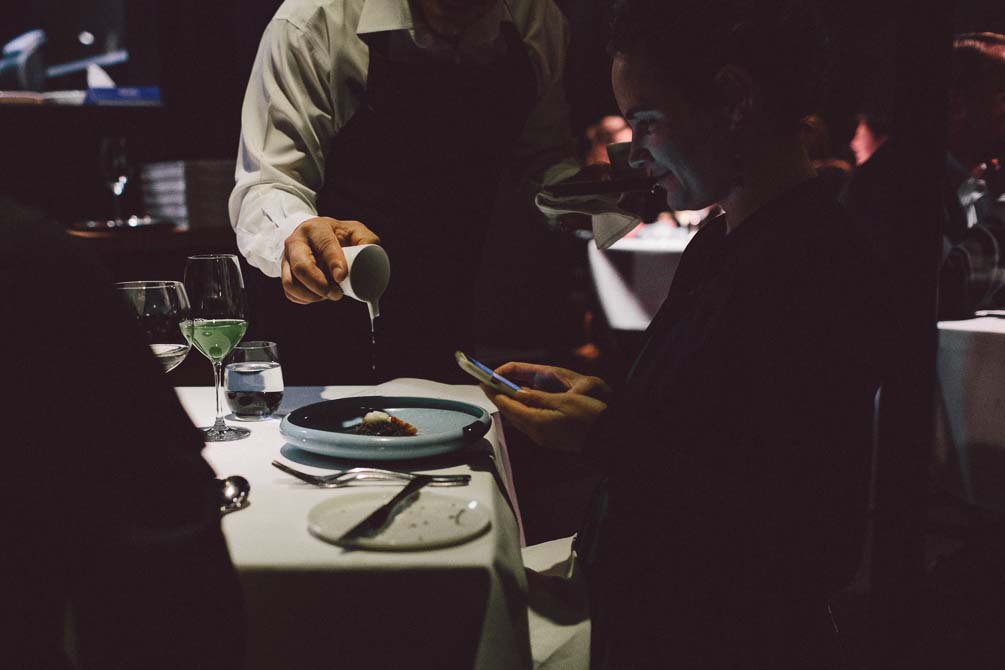 Waiter pouring sauce to Marron dish